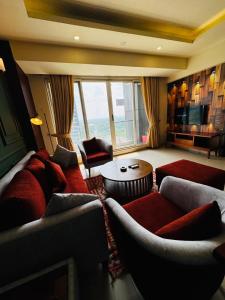 a living room with couches and a large window at Elysium Tower Luxury Apartments Islamabad Opposite Centaurus Mall in Islamabad