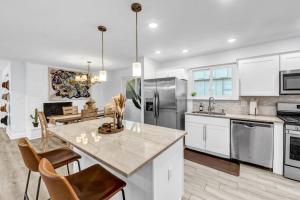 a kitchen with white cabinets and a marble counter top at Hot Tub Fire Pit 10 Min From DFW Airport in Irving