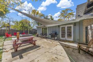 a patio with a picnic table and a grill at Hot Tub Fire Pit 10 Min From DFW Airport in Irving