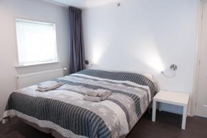een slaapkamer met een bed met twee handdoeken erop bij Ravennest in Epe