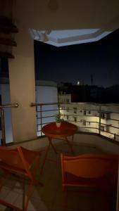 a table and chairs on a balcony at night at nouhaila Lag in Rabat