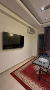 a living room with a table and a flat screen tv at nouhaila Lag in Rabat