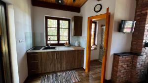 a kitchen with a sink and a clock on the wall at Domek 2-3 osobowy in Lejno