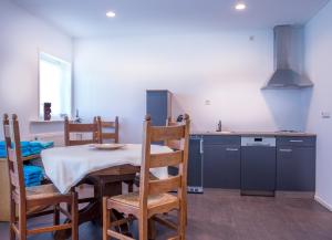 a kitchen with a table and chairs in a room at Ravennest in Epe