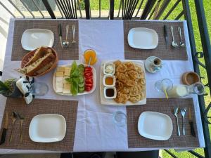 a table with white plates of food on it at Bujtina Tata in Curraj