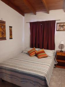 a bedroom with a bed with two pillows on it at Dpto playa in Las Grutas