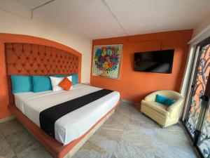 a bedroom with a large bed and a chair at Hotelito Lindo León in León +21 photos