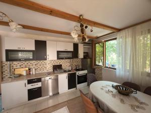 a kitchen with a table and a dining room at Paradise Villa in Gracanica