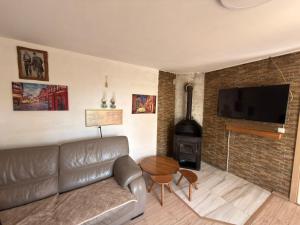 a living room with a leather couch and a fireplace at Paradise Villa in Gracanica