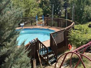 a swimming pool with a wooden deck and a woodenvisor around it at Paradise Villa in Gracanica +11 photos