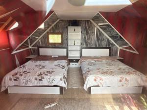 two beds in a room with red walls at Paradise Villa in Gracanica