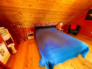 a bedroom with a blue bed in a wooden room at Solaris Apartman Ráckeve in Ráckeve