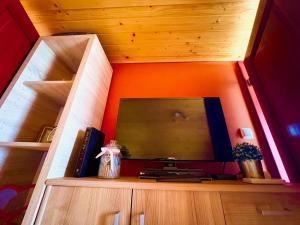 a tv on a wooden shelf in a room at Solaris Apartman Ráckeve in Ráckeve