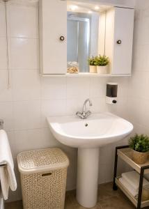 a white bathroom with a sink and a mirror at Ozias House in Oziás
