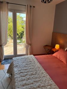 a bedroom with a bed and a sliding glass door at Orée de Villevert in Senlis