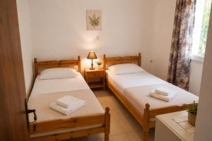 two twin beds in a room with a window at Ozias House in Oziás