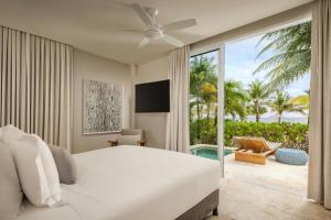 a bedroom with a bed and a view of the beach at Alaia Belize, Autograph Collection in San Pedro