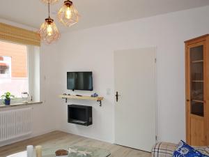 ein Wohnzimmer mit einem TV an einer weißen Wand in der Unterkunft Fischerhaus Bremerhaven in Bremerhaven
