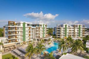an aerial view of a resort with a pool and palm trees at Alaia Belize, Autograph Collection in San Pedro