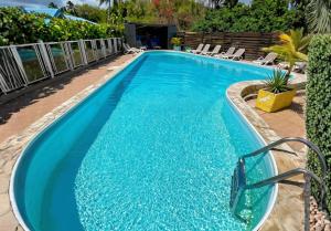 ein Schwimmbad mit blauem Wasser in einem Ferienort in der Unterkunft Hotel Le Rotabas in Sainte-Anne