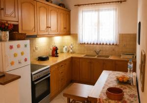 a kitchen with wooden cabinets and a white refrigerator at Ozias House in Oziás +7 photos