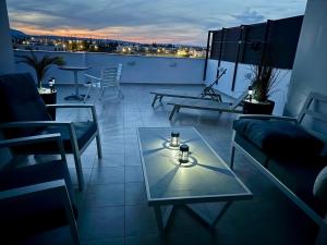 a living room with a glass table on a balcony at Artemis Executive Suite in Larnaca