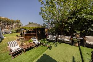 a garden with two chairs and a gazebo at Irene's Maisonette at Rafaella Resort in Kokóni