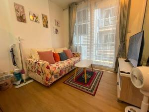 a living room with a couch and a window at Beautiful Sandy Jomtien Beach Pattaya at NeO Seaview Condo in Jomtien Beach