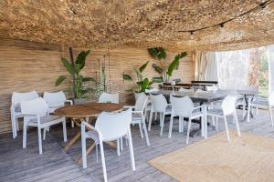 a dining room with white chairs and a table at Irene's Maisonette at Rafaella Resort in Kokóni