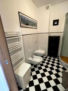 a bathroom with two toilets and a checkered floor at Bilocale fronte lago in Lovere