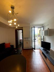 a living room with a couch and a chandelier at Bilocale fronte lago in Lovere +7 photos