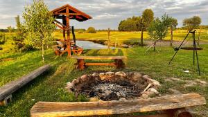 a park with a bench and a fire pit at Domek 2-3 osobowy in Lejno