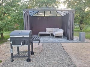 ein Grill und eine Couch in einem Zelt in der Unterkunft Czarwoli in Wola Bokrzycka