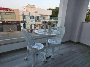 a table with two chairs and a vase with flowers on a balcony at Casa marsa in Gammarth