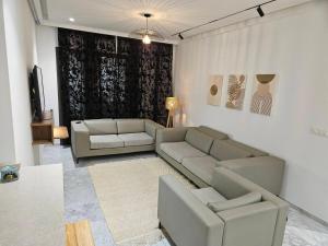 a living room with two couches and a television at Casa marsa in Gammarth