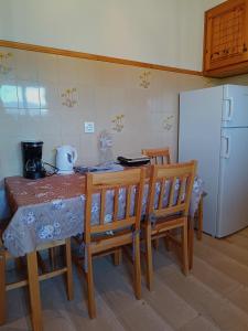 a kitchen with a table and chairs and a refrigerator at Eftichia Apartment in Roda +33 photos