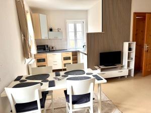 a kitchen with a table and chairs in a room at Süße Wohnung im Grünen in Weiler