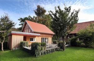 a wooden building with a bench in a yard at Süße Wohnung im Grünen in Weiler