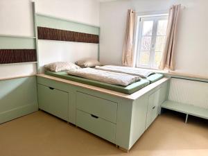 a bed in a room with a window at Süße Wohnung im Grünen in Weiler