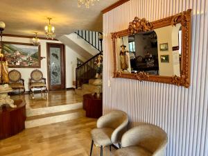 a living room with a mirror and some chairs at Casa Hidalgo Ecuador in Cumbayá