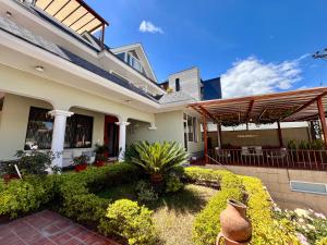 a house with a garden in front of it at Casa Hidalgo Ecuador in Cumbayá