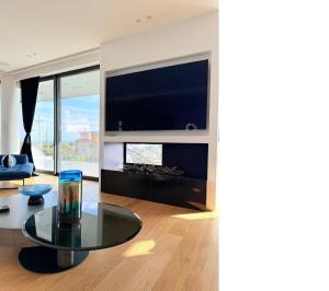 a living room with a glass table and a tv at Wiile State in Athánatoi