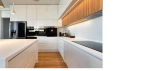 a kitchen with white cabinets and black appliances at Wiile State in Athánatoi
