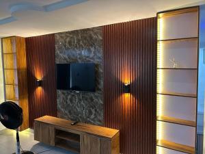 a room with a table and a tv on a wall at Cozy Nooks in Ijaiye