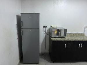a kitchen with a refrigerator and a microwave at Cozy Nooks in Ijaiye