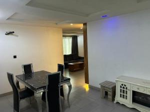 a dining room with a table and chairs and a couch at Cozy Nooks in Ijaiye