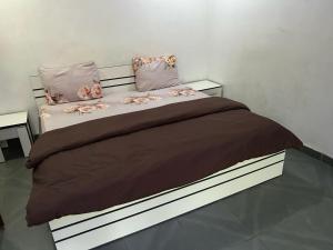 a bedroom with a large bed with pink flowers on it at Cozy Nooks in Ijaiye