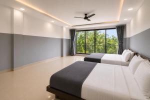 a bedroom with two beds and a window at SAVRAJ Stay Beach Goa in Candolim +5 photos