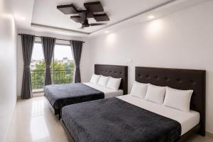 a bedroom with two beds and a balcony at SAVRAJ Stay Beach Goa in Candolim