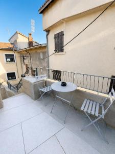 a table and chairs on a balcony of a building at Le Bourg - Studio 2pers -Climatisation et terrasse in Bourg-lès-Valence